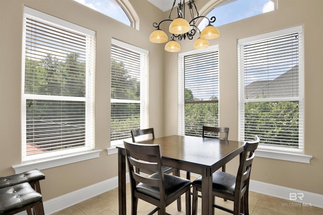 dining room featuring baseboards, light tile patterned floors, and a chandelier