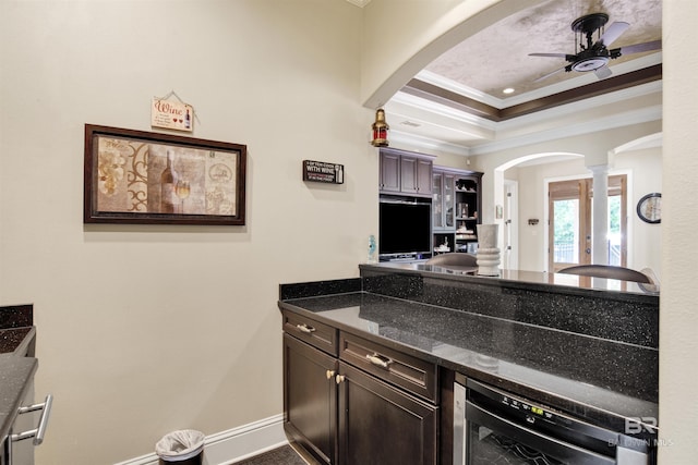 bar featuring crown molding, ceiling fan, arched walkways, wine cooler, and ornate columns