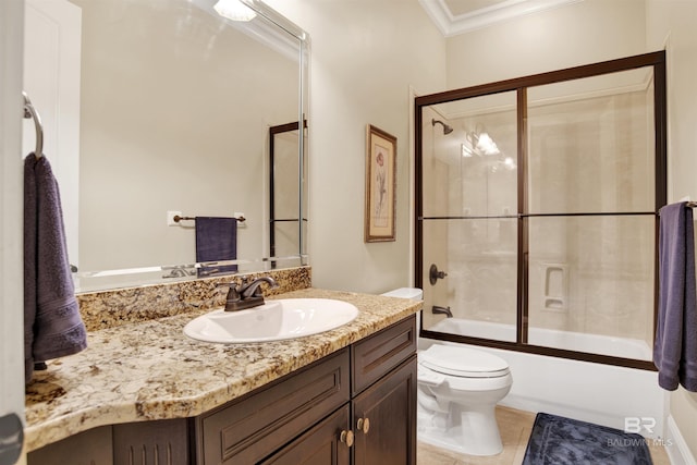 bathroom featuring tile patterned flooring, vanity, combined bath / shower with glass door, toilet, and ornamental molding