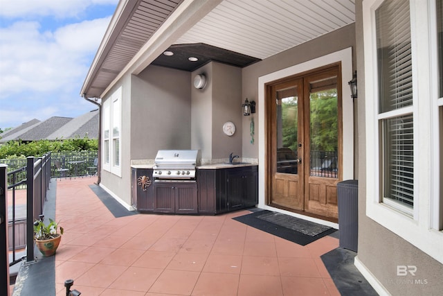 view of patio / terrace with french doors, a sink, grilling area, and an outdoor kitchen