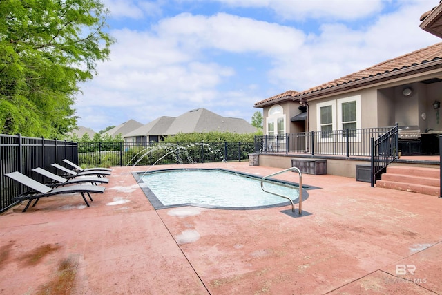 view of swimming pool featuring grilling area, fence, a patio area, and a fenced in pool