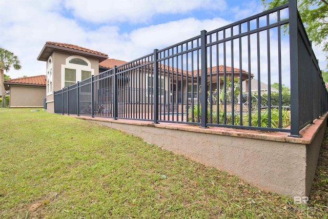 view of gate featuring fence and a yard