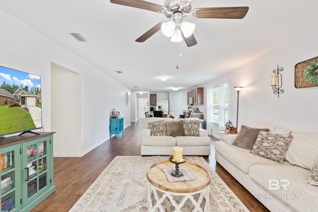 living room with dark wood-type flooring and ceiling fan