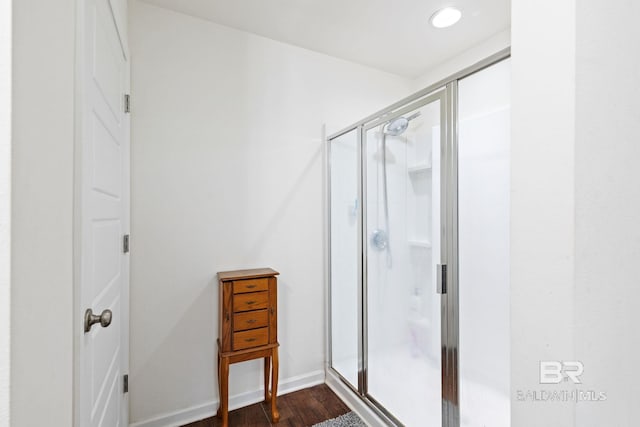 bathroom featuring a shower with door and wood-type flooring