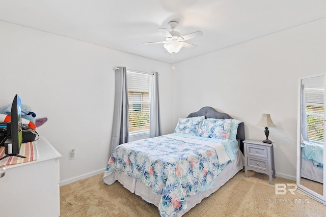 carpeted bedroom featuring multiple windows and ceiling fan