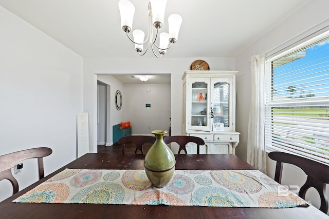 dining area with a notable chandelier and dark hardwood / wood-style floors