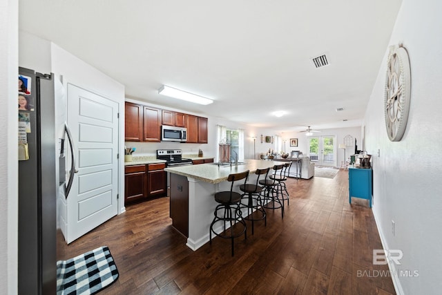 kitchen with dark wood-type flooring, a kitchen island, ceiling fan, stainless steel appliances, and sink