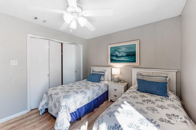 bedroom with a closet, light hardwood / wood-style floors, and ceiling fan