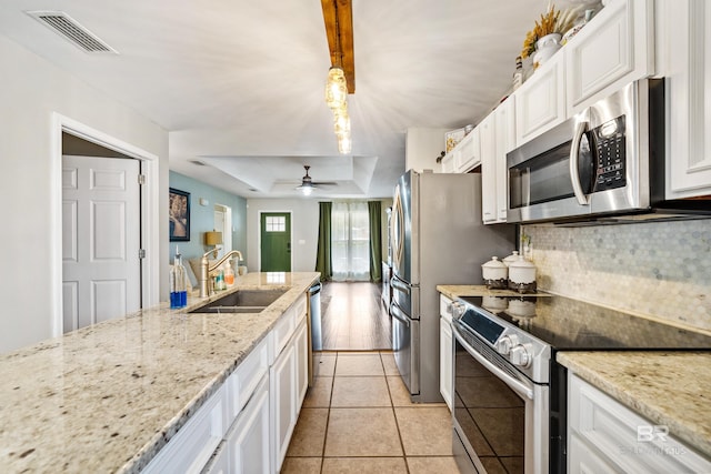 kitchen featuring light tile patterned flooring, sink, decorative light fixtures, stainless steel appliances, and white cabinets