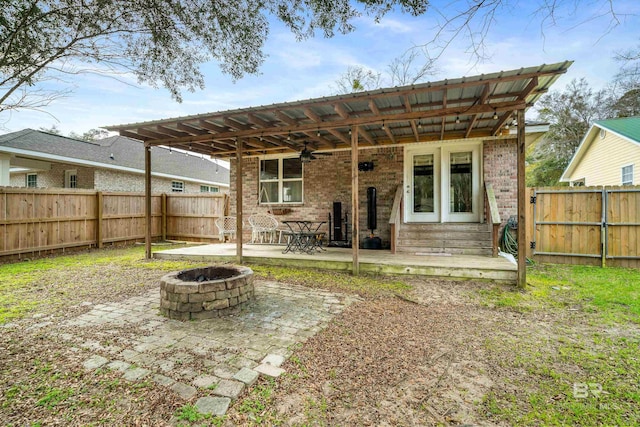 back of property with a patio and an outdoor fire pit