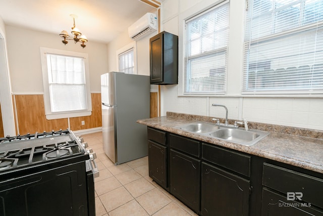 kitchen with stainless steel fridge, wooden walls, a wall unit AC, gas stove, and sink