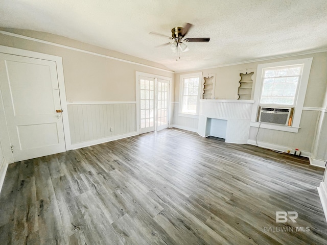 unfurnished living room featuring ceiling fan, cooling unit, built in features, wood-type flooring, and a textured ceiling