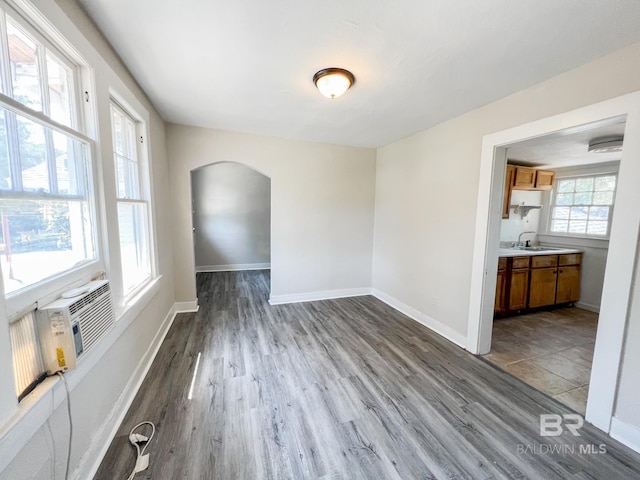 unfurnished dining area featuring cooling unit, hardwood / wood-style floors, and sink