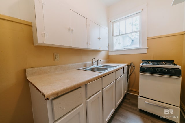 kitchen with white cabinets, dark hardwood / wood-style flooring, sink, and white gas range