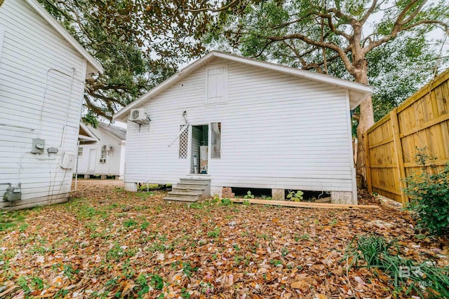 rear view of property with a wall mounted air conditioner