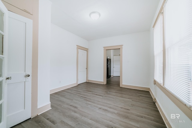 unfurnished bedroom with a closet, black fridge, and light hardwood / wood-style floors