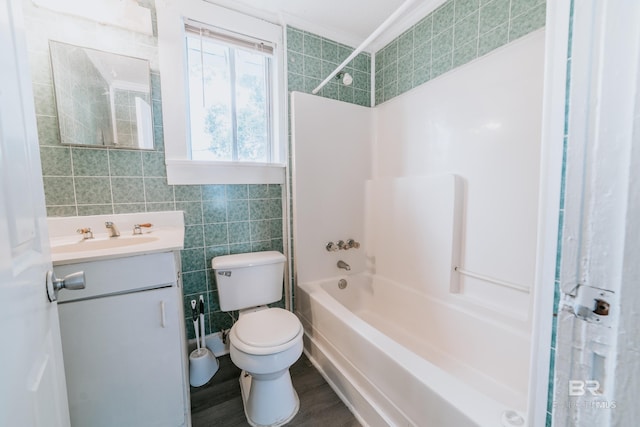 full bathroom featuring toilet, hardwood / wood-style floors, tile walls, tub / shower combination, and vanity