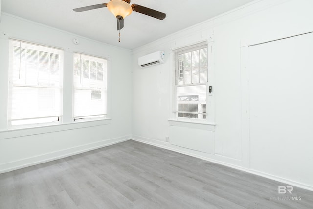 empty room with ceiling fan, crown molding, light hardwood / wood-style floors, and an AC wall unit