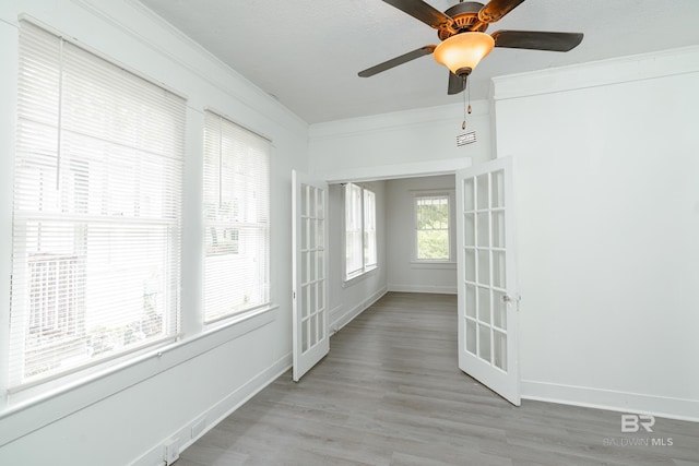 unfurnished sunroom featuring ceiling fan and french doors