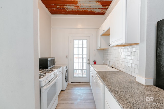 kitchen featuring plenty of natural light, sink, white appliances, and white cabinetry