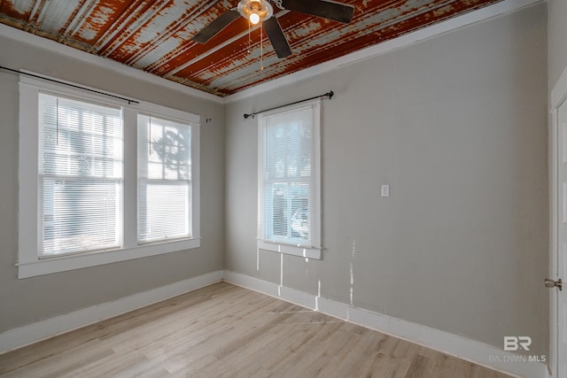 spare room with ceiling fan, a wealth of natural light, and light hardwood / wood-style floors