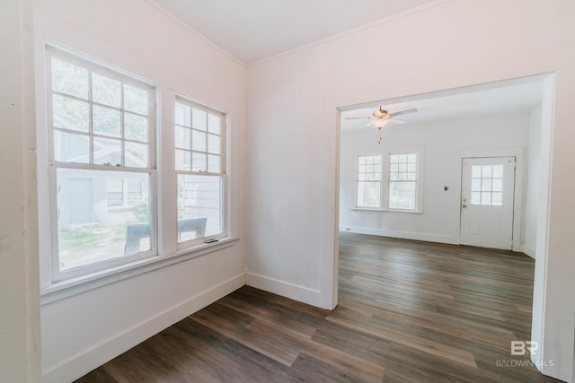 empty room with ceiling fan, dark hardwood / wood-style flooring, and ornamental molding