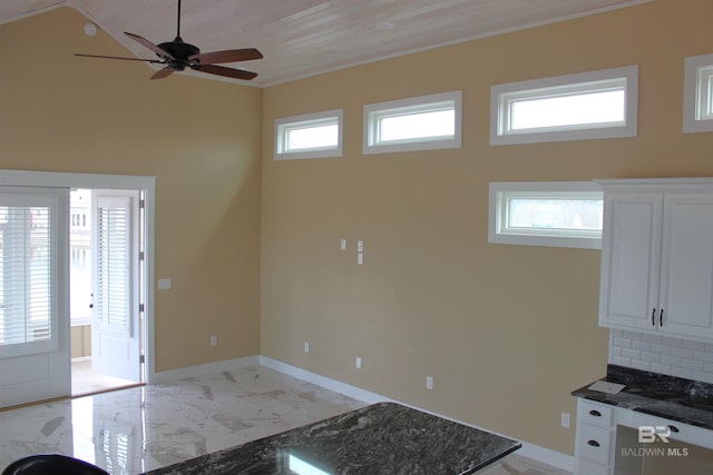 kitchen featuring white cabinetry, ceiling fan, wooden ceiling, tasteful backsplash, and dark stone counters