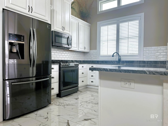 kitchen with stainless steel fridge, range with electric stovetop, tasteful backsplash, white cabinetry, and kitchen peninsula
