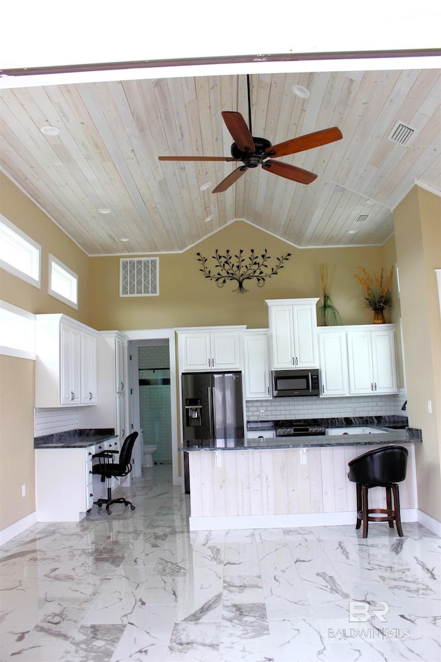kitchen featuring tasteful backsplash, white cabinets, wooden ceiling, and appliances with stainless steel finishes