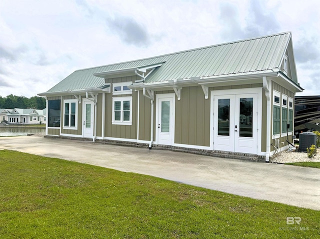 rear view of house featuring central AC, a yard, and french doors