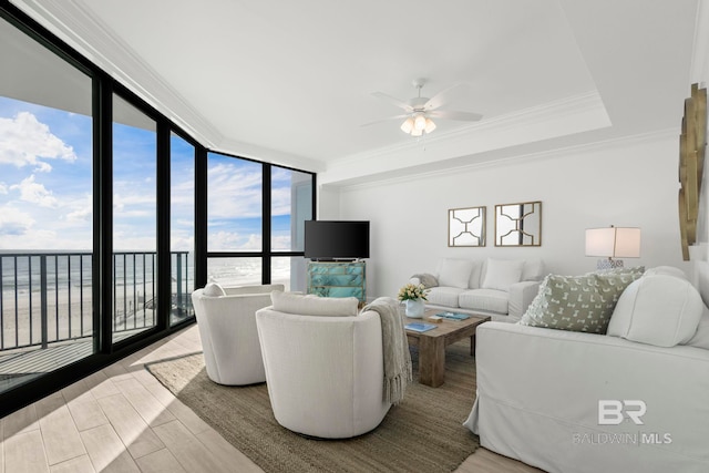 living room with floor to ceiling windows, ceiling fan, light hardwood / wood-style flooring, crown molding, and a water view