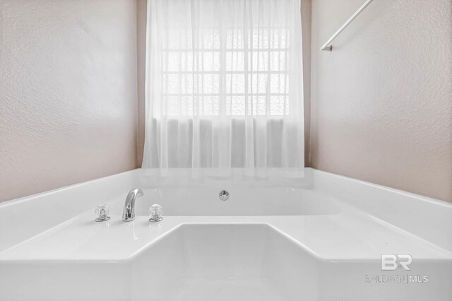 27913 Turkey Branch Dr, Daphne, AL 36526 - bathroom featuring a textured wall and a garden tub