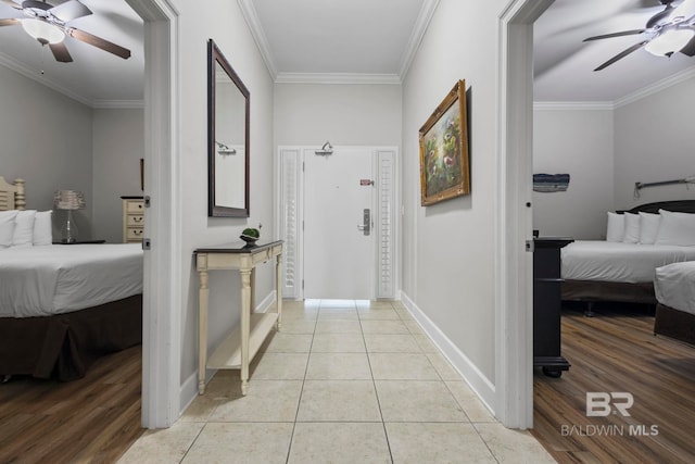 hallway featuring crown molding, baseboards, and light tile patterned floors