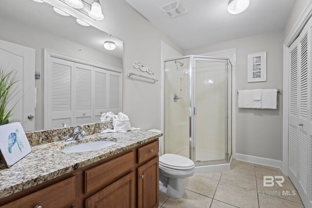 full bath with a shower stall, vanity, a closet, and tile patterned floors