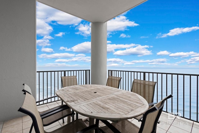 balcony featuring outdoor dining area and a water view