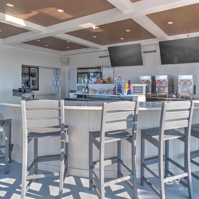 bar with wood walls, coffered ceiling, beam ceiling, and recessed lighting