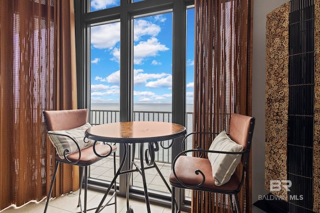 dining room with a water view and light tile patterned flooring