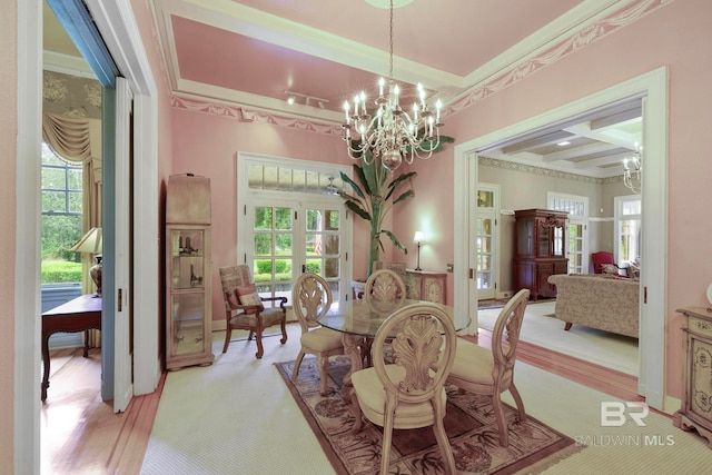 dining space with coffered ceiling, crown molding, light wood-type flooring, a raised ceiling, and a chandelier