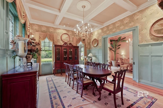 dining area with a notable chandelier, coffered ceiling, light hardwood / wood-style floors, beamed ceiling, and ornamental molding