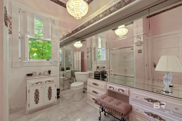 bathroom featuring tile patterned floors, vanity, a chandelier, and toilet