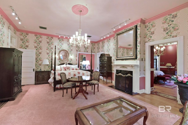 dining area featuring a notable chandelier, a fireplace, and track lighting