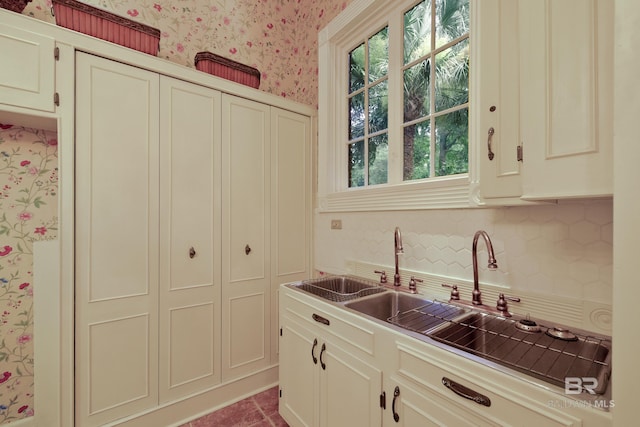 kitchen with light tile patterned floors, tasteful backsplash, cream cabinetry, and a healthy amount of sunlight