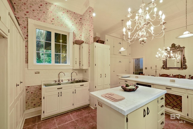 kitchen with pendant lighting, sink, dark tile patterned flooring, a chandelier, and a center island