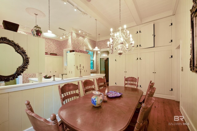 dining area featuring a notable chandelier, track lighting, beam ceiling, and hardwood / wood-style floors