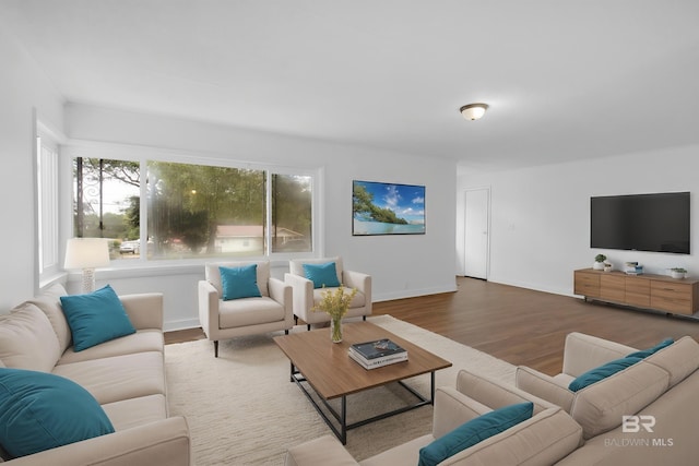 living area with baseboards and wood finished floors