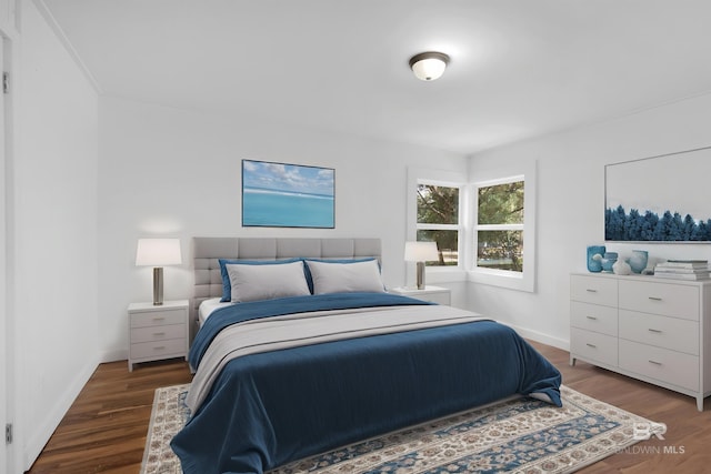 bedroom with baseboards and wood finished floors