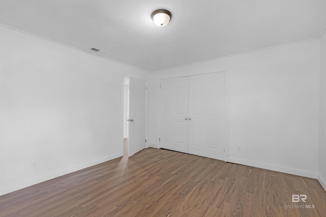 empty room with visible vents, baseboards, and wood finished floors