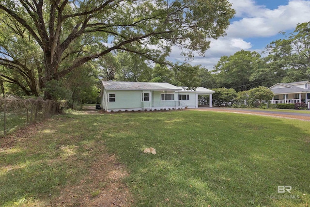 view of front of property featuring an attached carport, fence, driveway, and a front yard