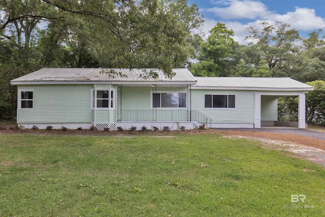 ranch-style home featuring covered porch, an attached carport, a front lawn, and aphalt driveway