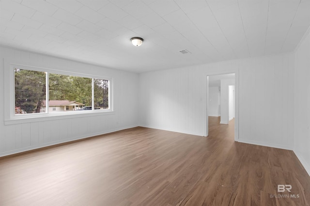 unfurnished room with visible vents and wood finished floors